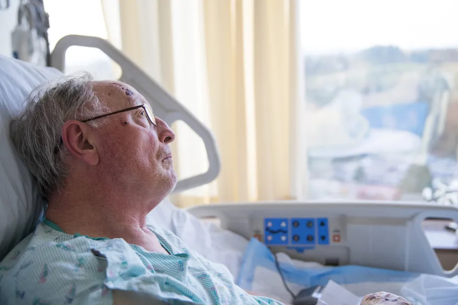 A patient in bed staring out the window