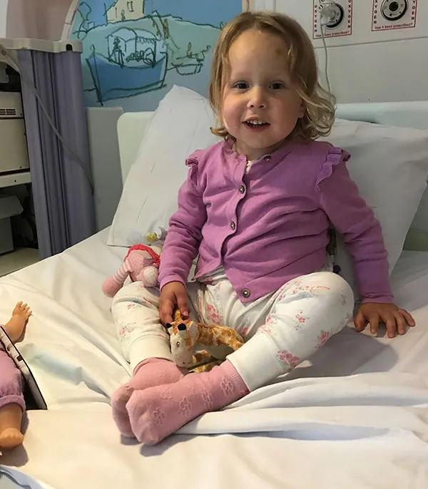 Photo of Elena sitting on a hospital bed