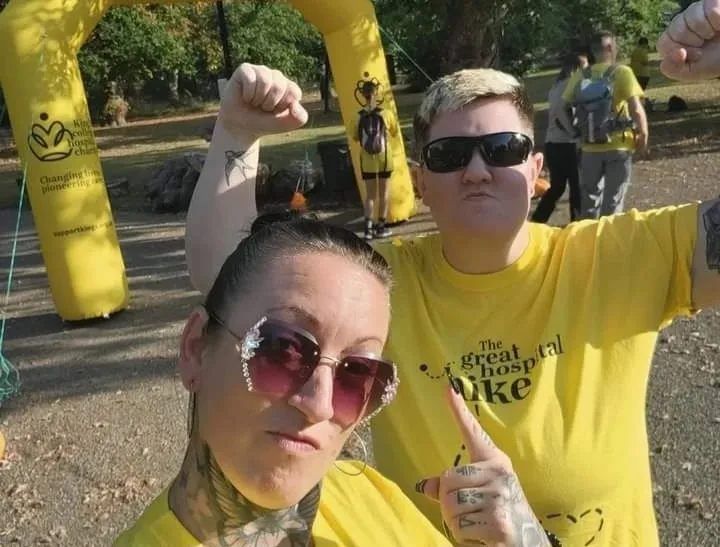 Two women standing at the finish line to the Great Hospital Hike cheering