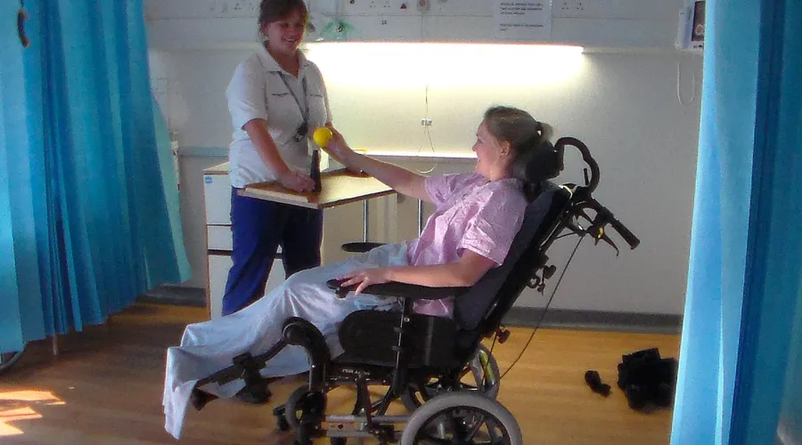 Photo of patient using a specialist wheelchair with a physio