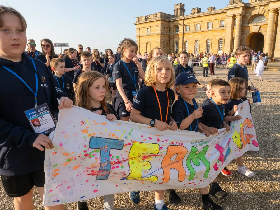 Children holding a Team King's banner at the opening ceremony 