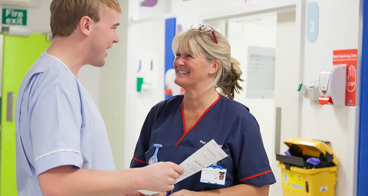Two members of King's staff smiling in the middle of the ward