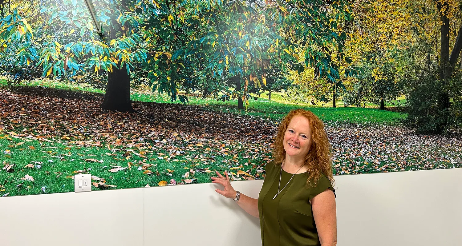 Gail Scott-Spicer, the Charity's CEO, standing in front of artwork of Ruskin Park in the newly refurbished ED Majors