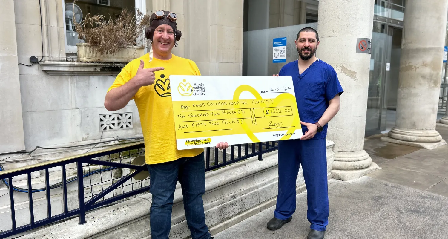 Gary and his former surgeon holding a giant yellow cheque 