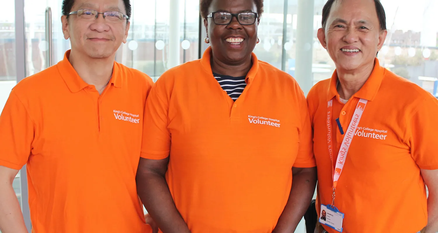 Three volunteers smiling at the camera