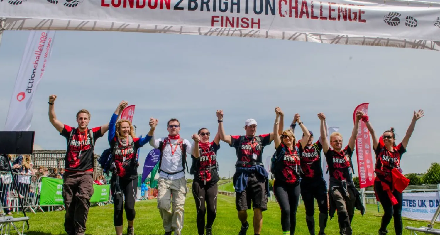 A group of people walk towards camera with their hands in the air