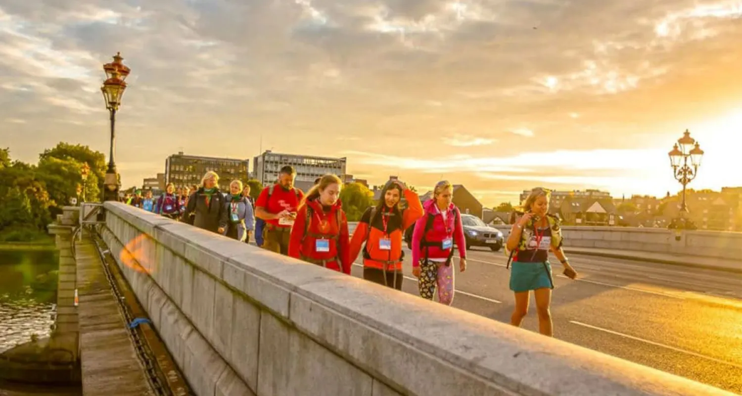 a group of people walk over a London Bridge at dusk