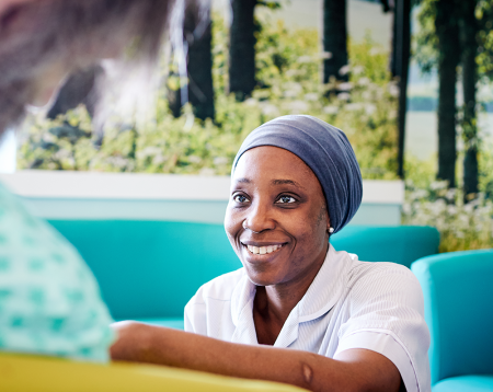 Nurse in a clinical setting smiling at a patient