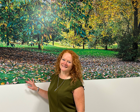 Gail Scott-Spicer, the Charity's CEO, standing in front of artwork of Ruskin Park in the newly refurbished ED Majors