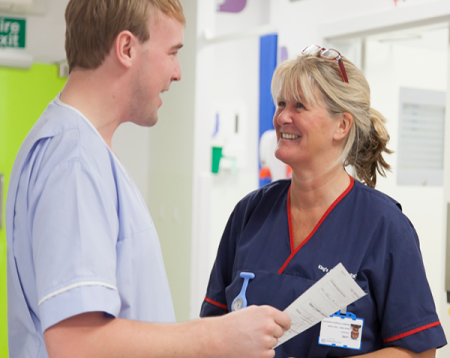 Two members of King's staff smiling in the middle of the ward