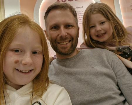 David smiling with his two daughters
