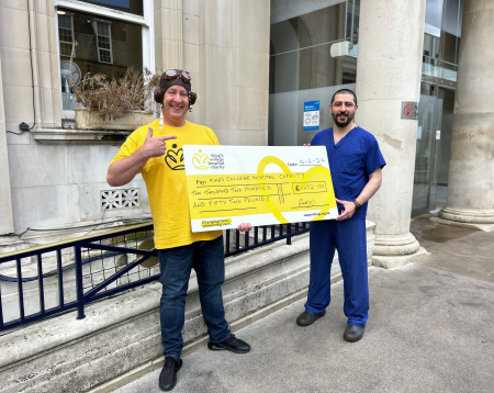 Gary and his former surgeon holding a giant yellow cheque 