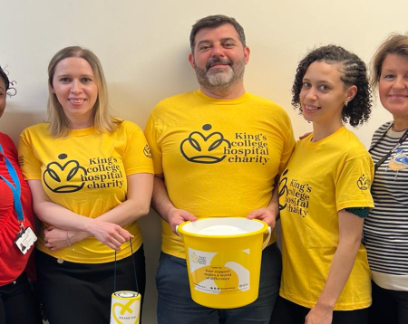 Georgios and colleagues in King's College Hospital Charity branded yellow t-shirts and holding a collection bucket