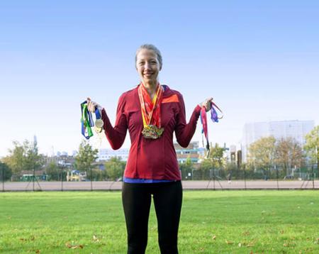 Photo of Helen standing in a field holding medals