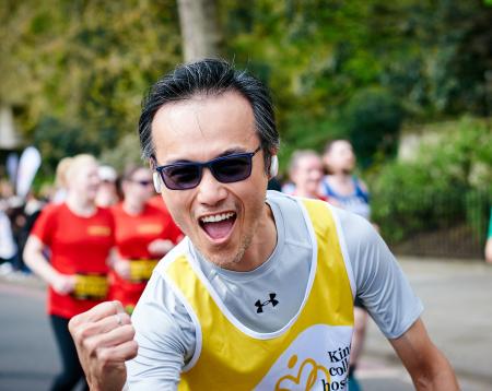 Man in the middle of a run and smiling at the camera