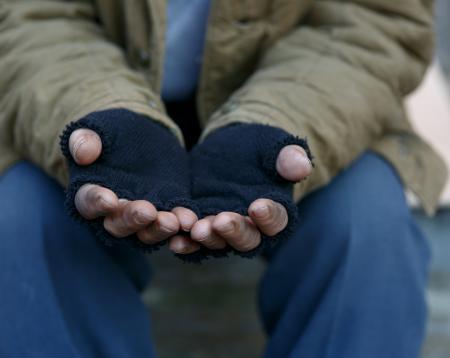 A homeless man wearing gloves