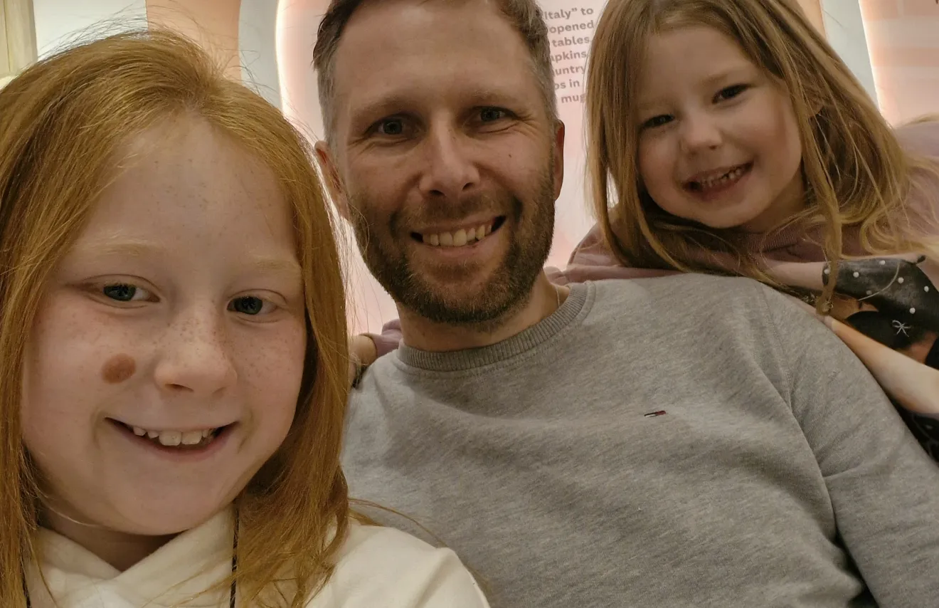 David smiling with his two daughters