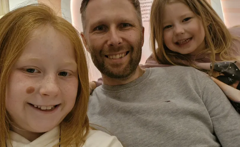 David smiling with his two daughters