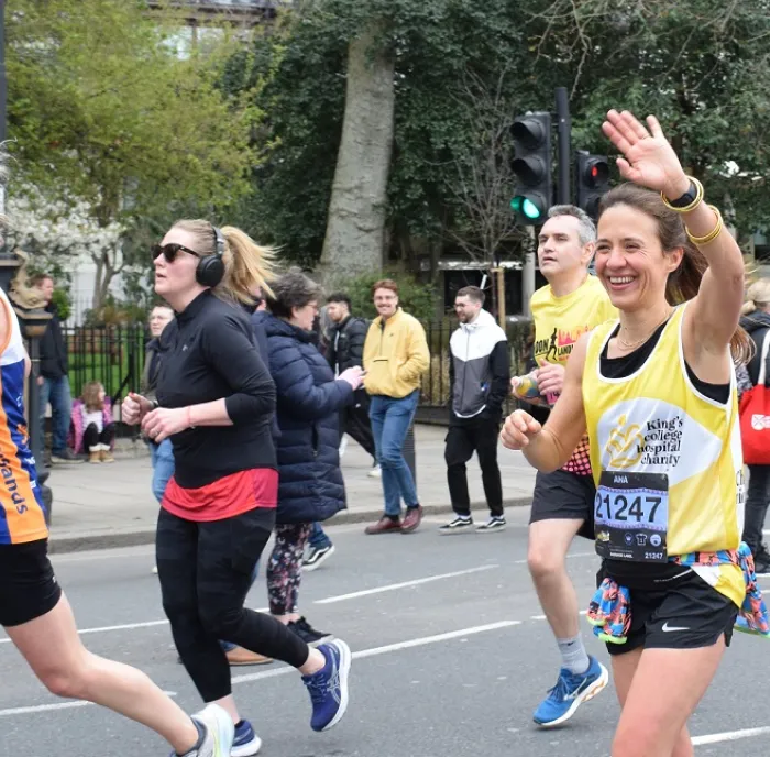 Woman smiling and waving while running