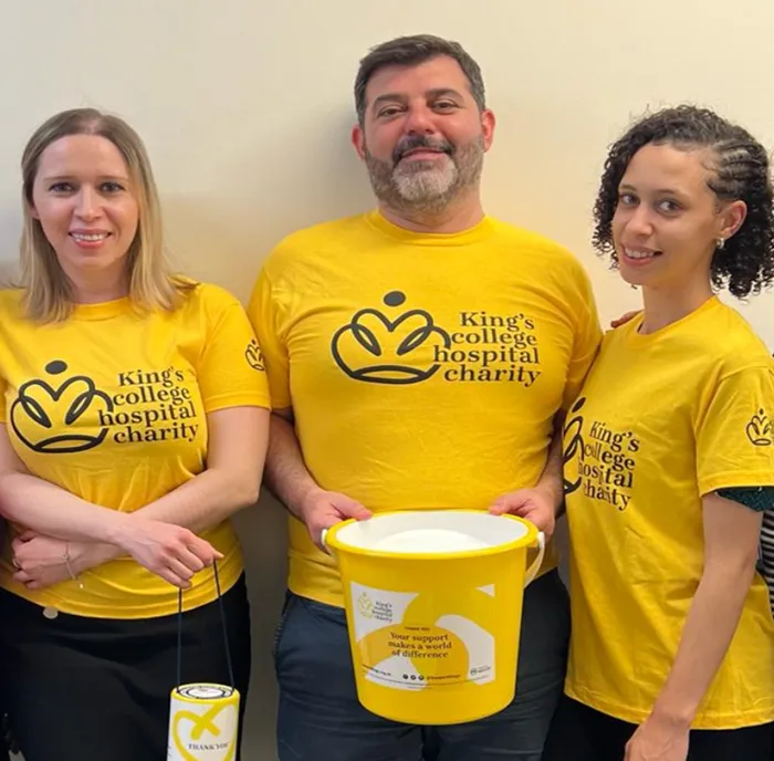 Georgios and colleagues in King's College Hospital Charity branded yellow t-shirts and holding a collection bucket