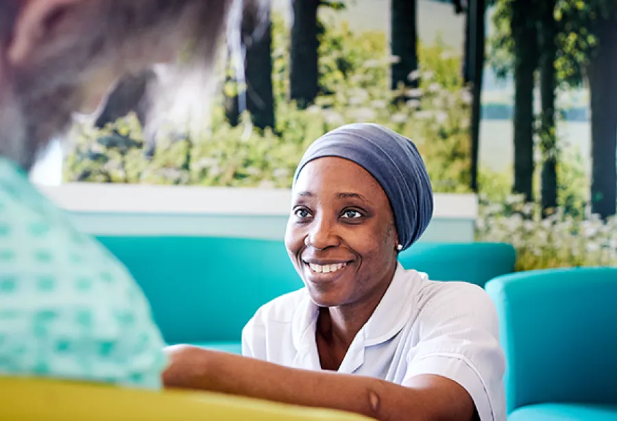 Nurse in a clinical setting smiling at a patient