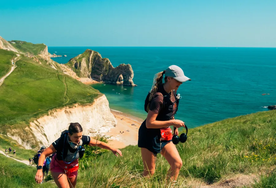 Two walkers walking in front of a beautiful Dorset coastline