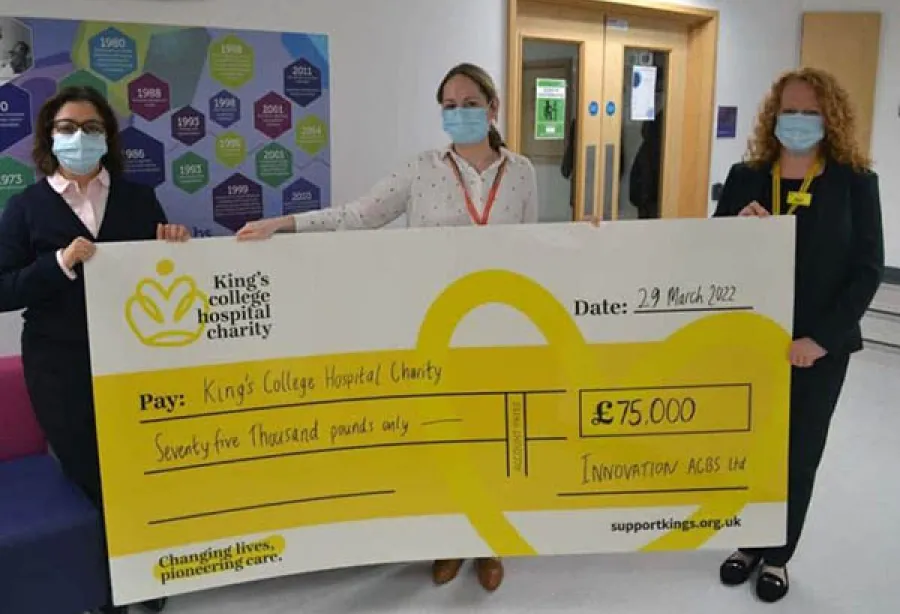 Picture of three people holding a giant cheque for £75,000 made by Innovation Building Services to support King's College Hospital Charity