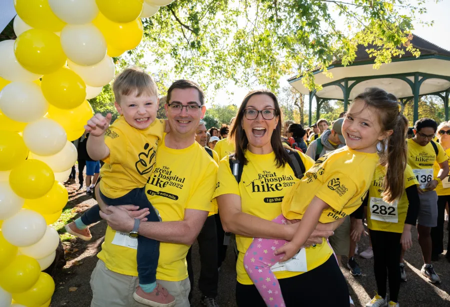 Matilda, her mum, dad, and brother at the start line to the Great Hospital Hike, wearing yellow t-shirts
